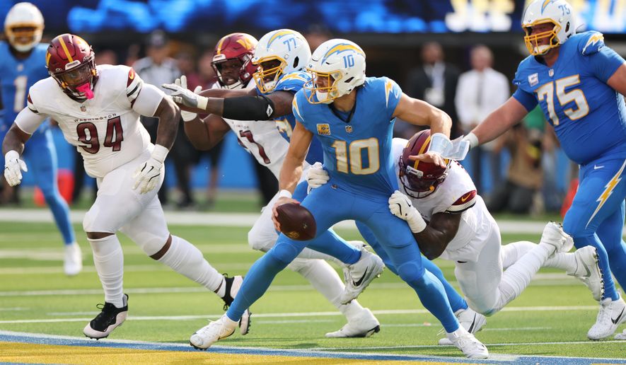 Los Angeles Chargers quarterback Justin Herbert (10) is sacked by Washington Commanders defensive end Dorance Armstrong during the second half of an NFL football game Sunday, Oct. 5, 2025, in Inglewood, Calif. (AP Photo/Eric Thayer)