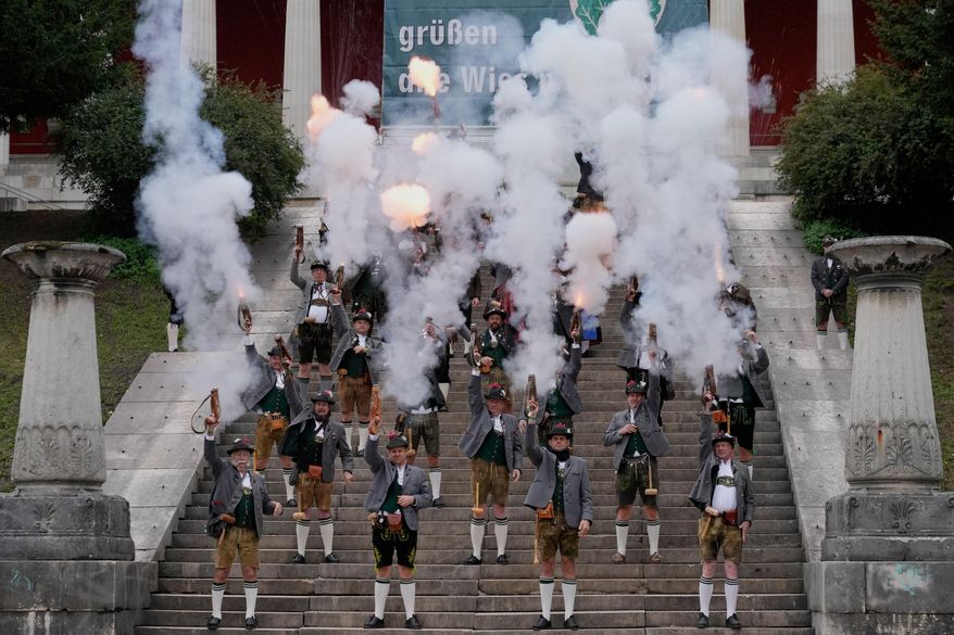 Bavarian riflemen and women in traditional costumes fire their muzzle loaders on the last day of the 190th Oktoberfest beer festival in Munich, Germany, Sunday, Oct. 5, 2025. (AP Photo/Matthias Schrader)