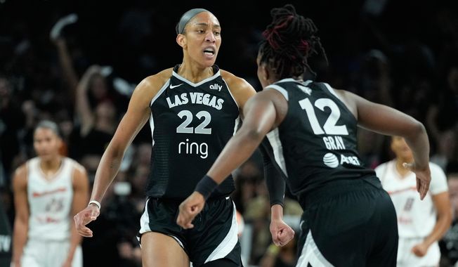 Las Vegas Aces center A'ja Wilson (22) and guard Chelsea Gray (12) celebrate during the first half in Game 2 of the WNBA basketball finals against the Phoenix Mercury, Sunday, Oct. 5, 2025, in Las Vegas. (AP Photo/John Locher)
