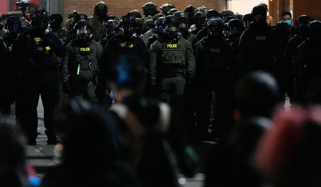 Law enforcement officers standoff against demonstrators outside a U.S. Immigration and Customs Enforcement facility during a protest on Saturday, Oct. 4, 2025, in Portland, Ore. (AP Photo/Jenny Kane)