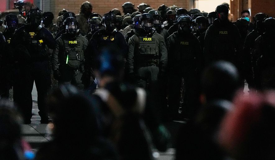 Law enforcement officers standoff against demonstrators outside a U.S. Immigration and Customs Enforcement facility during a protest on Saturday, Oct. 4, 2025, in Portland, Ore. (AP Photo/Jenny Kane)