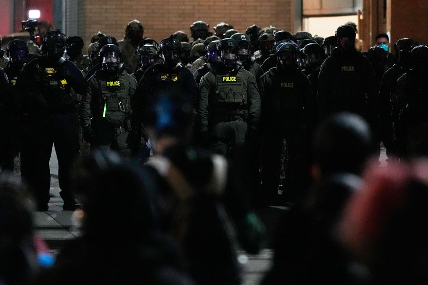 Law enforcement officers standoff against demonstrators outside a U.S. Immigration and Customs Enforcement facility during a protest on Saturday, Oct. 4, 2025, in Portland, Ore. (AP Photo/Jenny Kane)