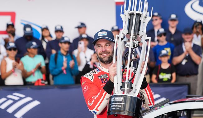 Shane van Gisbergen celebrates in Victory Lane after winning a NASCAR Cup Series auto race at Charlotte Motor Speedway, Sunday, Oct. 5, 2025, in Concord, N.C. (AP Photo/Matt Kelley)