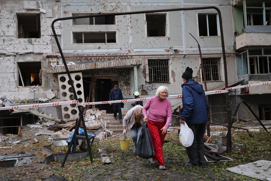 Residents take their belongings from their house destroyed by a Russian strike in Zaporizhzhia, Ukraine, Sunday, Oct. 5, 2025. (AP Photo/Kateryna Klochko)