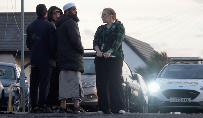 Locals view the damage outside the front entrance of the mosque in Peacehaven, following a suspected arson attack, in East Sussex, England, Sunday, Oct. 5, 2025. (Jamie Lashmar/PA via AP)