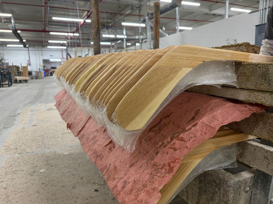 Wooden hockey sticks are stacked as they move along the assembly line at the Roustan Hockey factory, which is the last major manufacturer of hockey sticks in Canada on Aug. 27, 2025 in Brantford, Ontario. (AP Photo/Kelvin Chan)