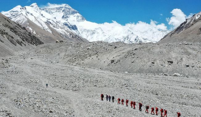 FILE - In this May 16, 2020 aerial photo released by Xinhua News Agency, Chinese surveyors hike toward a higher spot from the base camp on Mount Qomolangma at an altitude of 5,200 meters. (Jigme Dorje/Xinhua via AP, File)