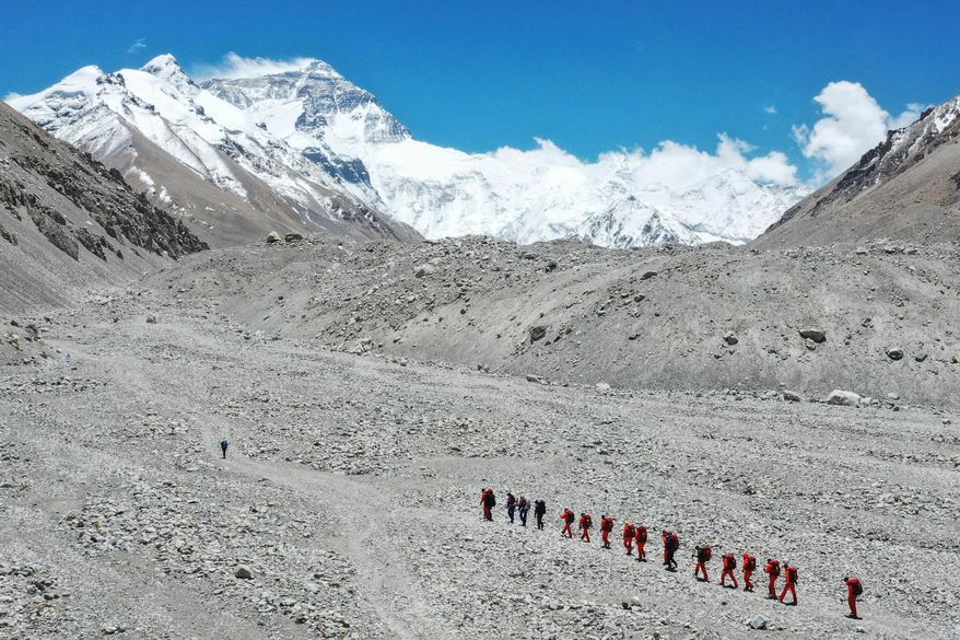 FILE - In this May 16, 2020 aerial photo released by Xinhua News Agency, Chinese surveyors hike toward a higher spot from the base camp on Mount Qomolangma at an altitude of 5,200 meters. (Jigme Dorje/Xinhua via AP, File)