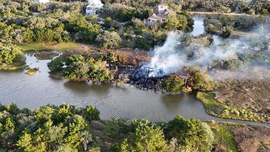 In this aerial view image taken from video from WCBD, smoke rises from a house fire on Edisto Island, S.C., Saturday, Oct. 4, 2025. (WCBD via AP)