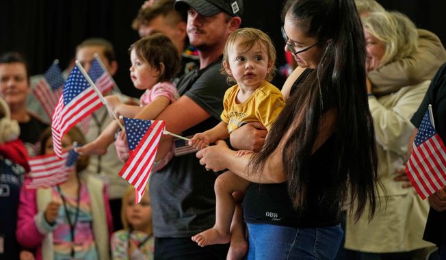 Afrikaner refugees from South Africa holding American flags arrive, May 12, 2025, at Dulles International Airport in Dulles, Va. (AP Photo/Julia Demaree Nikhinson, File)