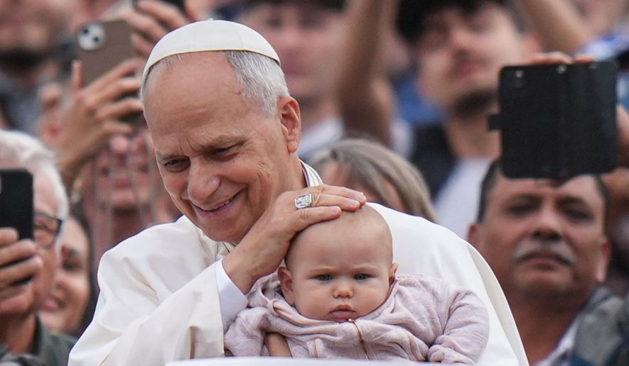 Pope Leo XIV blesses a child at the end of a Mass for the Jubilee of Migrants and Missionaries in St. Peter's Square at the Vatican, Sunday, Oct. 5, 2025. (AP Photo/Alessandra Tarantino)