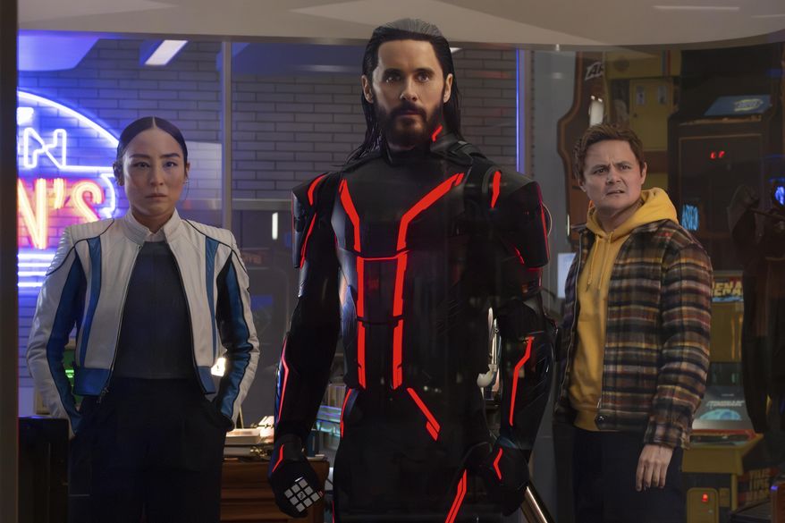 This image released by Disney shows Greta Lee, from left, Jared Leto and Arturo Castro in a scene from "Tron: Ares." (Disney via AP)