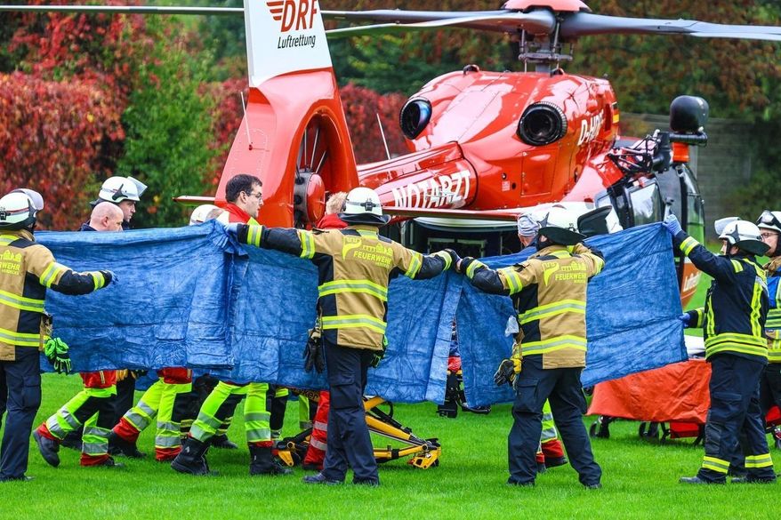 Emergency services stand next to a rescue helicopter in Herdecke, Germany, Tuesday, Oct. 7, 2025, after the newly elected mayor of Herdecke, Iris Stalzer, has been found critically injured in her apartment. (Alex Talash/dpa via AP)