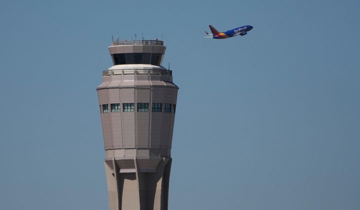 A plane takes off near the air traffic control tower at Harry Reid International Airport, Tuesday, Oct. 7, 2025, in Las Vegas. (AP Photo/John Locher)
