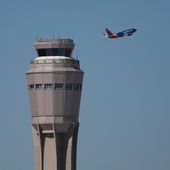A plane takes off near the air traffic control tower at Harry Reid International Airport, Tuesday, Oct. 7, 2025, in Las Vegas. (AP Photo/John Locher)