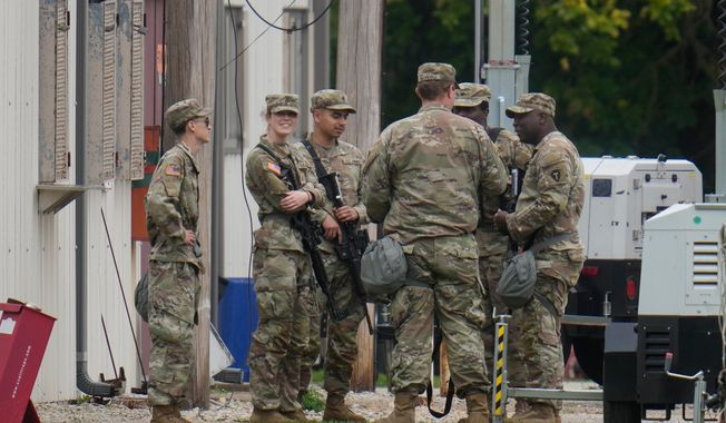 Military personnel in uniforms with the Texas National Guard patch at the U.S. Army Reserve Center are seen, Tuesday, Oct. 7, 2025, in in Elwood, Ill, a suburb of Chicago. (AP Photo Erin Hooley)