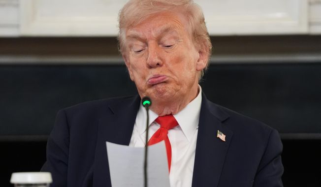President Donald Trump reads a note handed to him by Secretary of State Marco Rubio during a roundtable meeting on antifa in the State Dining Room at the White House, Wednesday, Oct. 8, 2025, in Washington. (AP Photo/Evan Vucci)