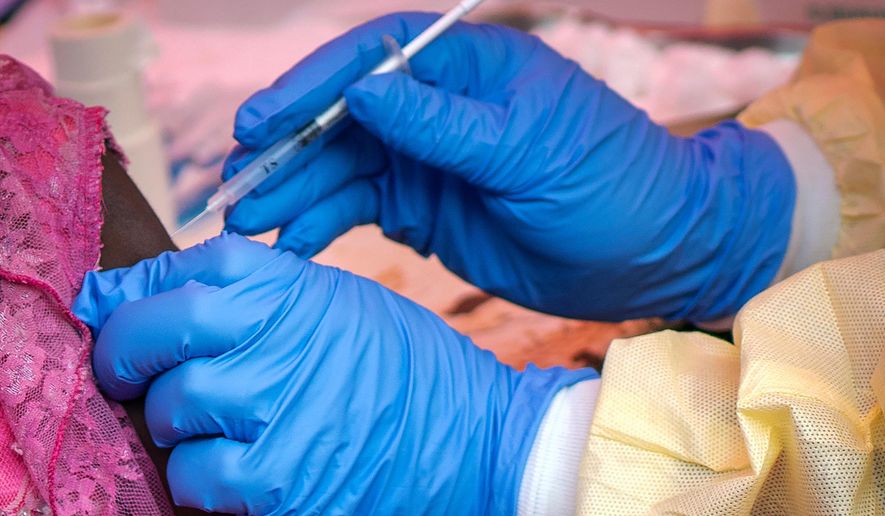 FILE - In this Saturday, July 13, 2019 file photo, a person is vaccinated against Ebola in Beni, Congo. (AP Photo/Jerome Delay, File)