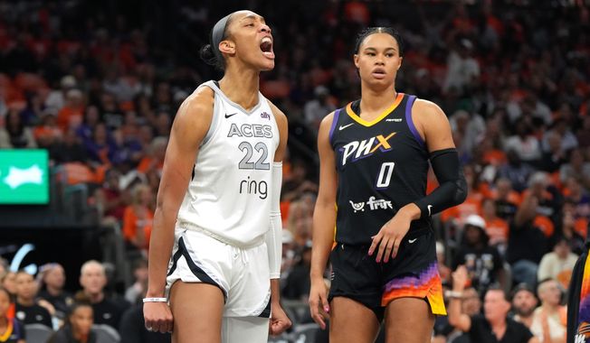 Las Vegas Aces center A'ja Wilson (22) reacts after scoring on Phoenix Mercury forward Satou Sabally during the first half of Game 3 of the WNBA basketball finals, Wednesday, Oct. 8, 2025, in Phoenix. (AP Photo/Rick Scuteri)