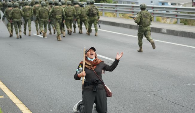 A woman shouts as soldiers arrive to clear the Pan-American Highway of demonstrators protesting the elimination of diesel subsidy by President Daniel Noboa's government, in Calderon, Ecuador, Thursday, Oct. 9, 2025. (AP Photo/Dolores Ochoa)