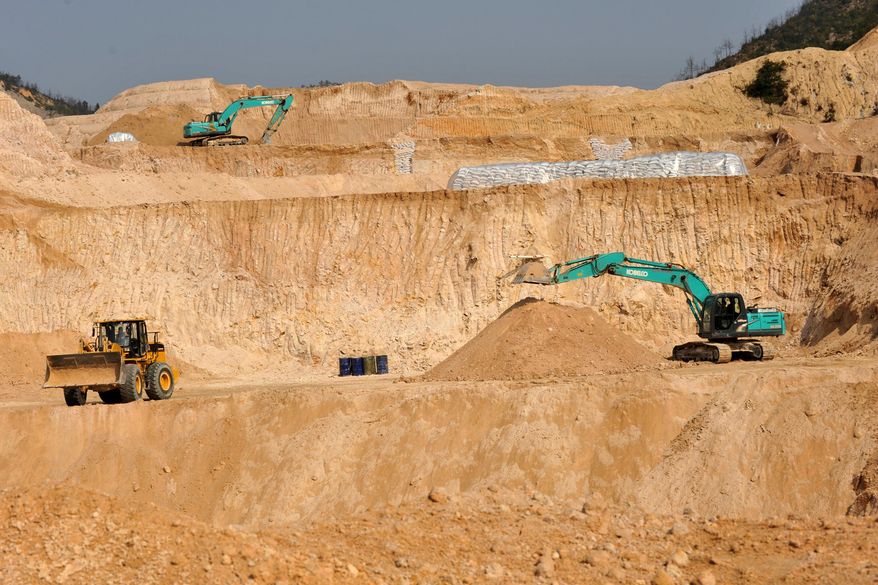Workers use machinery to dig at a rare earth mine in Ganxian county in central China's Jiangxi province on Dec. 30, 2010. (Chinatopix via AP, File)