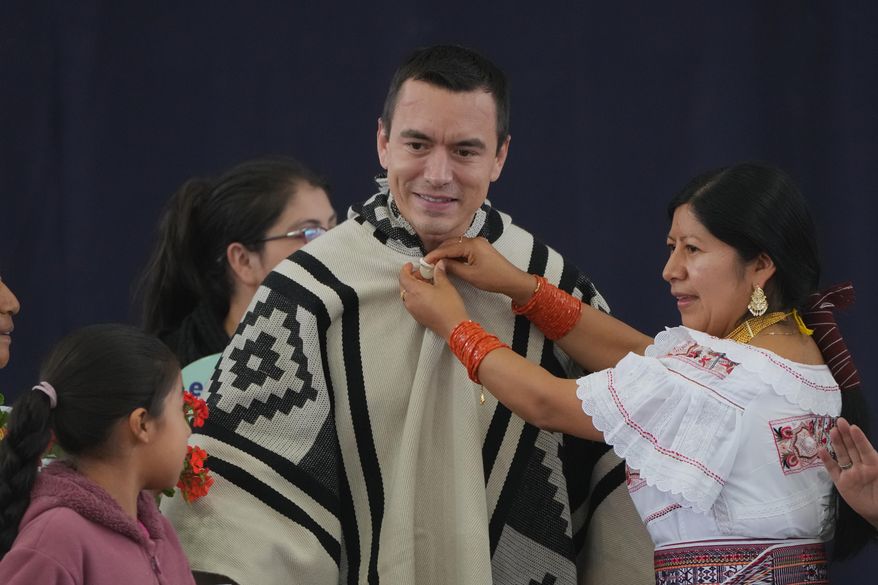 Ecuador's President Daniel Noboa receives a poncho as a gift during an event to deliver benefits and to decry the protests against diesel price hikes following his fuel subsidy cuts, in Otavalo, Ecuador, Wednesday, Sept. 24, 2025. (AP Photo/Dolores Ochoa)