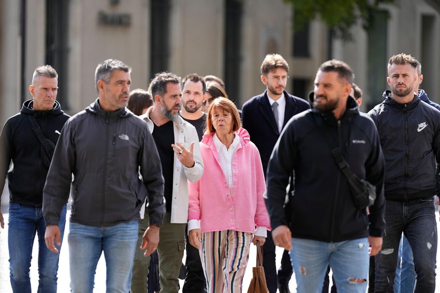 Gisele Pelicot and her son Florian Pelicot, third left, return to the courthouse during the appeals trial in the case of a man challenging his conviction, less than a year after the landmark verdict in a drugging and rape trial that shook France Thursday, Oct. 9, 2025 in Nimes, southern France. (AP Photo/Lewis Joly)