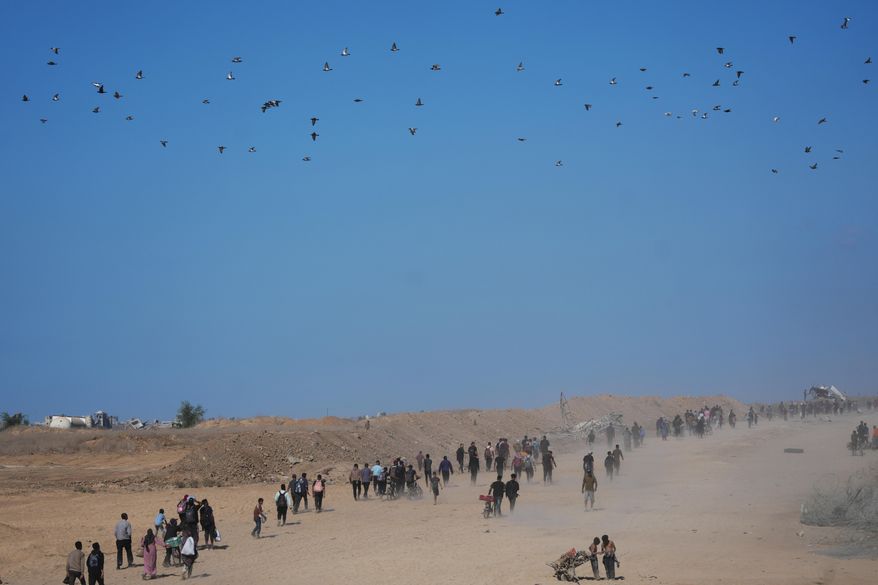 Displaced Palestinians walk toward Gaza City, in the northern Gaza Strip, Friday, Oct. 10, 2025, after Israel and Hamas agreed to a pause in their war and the release of the remaining hostages. (AP Photo/Jehad Alshrafi)