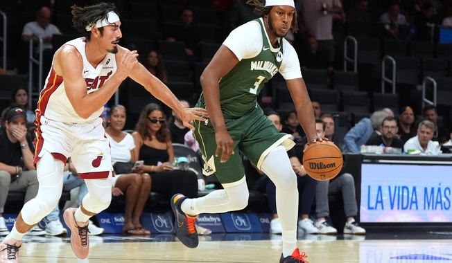 Milwaukee Bucks center Myles Turner (3) drives past Miami Heat guard Jaime Jaquez Jr. during the first half of a preseason NBA basketball game, Monday, Oct. 6, 2025, in Miami. (AP Photo/Rebecca Blackwell)