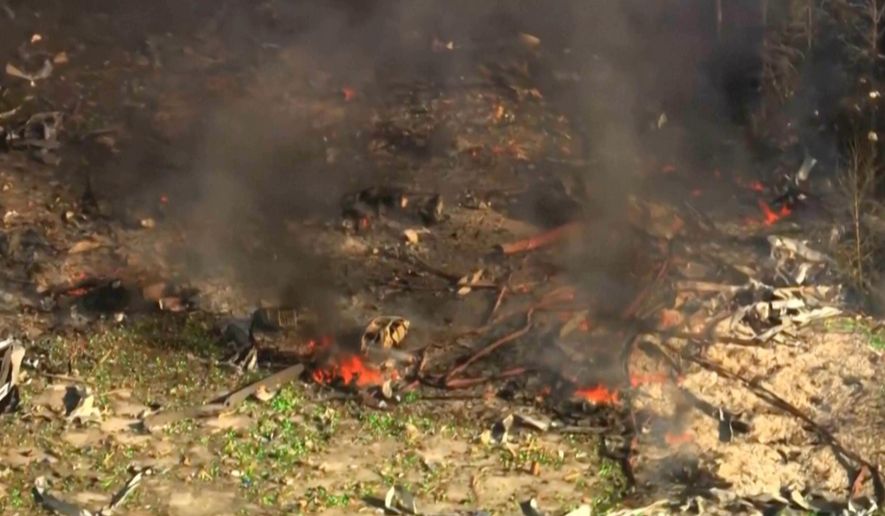 Smoke fills the air as debris covers the ground and vehicles after a powerful blast ripped through a military explosives manufacturing plant in Hickman County, Tenn., on Friday, Oct. 10, 2025. (WTVF-TV via AP)