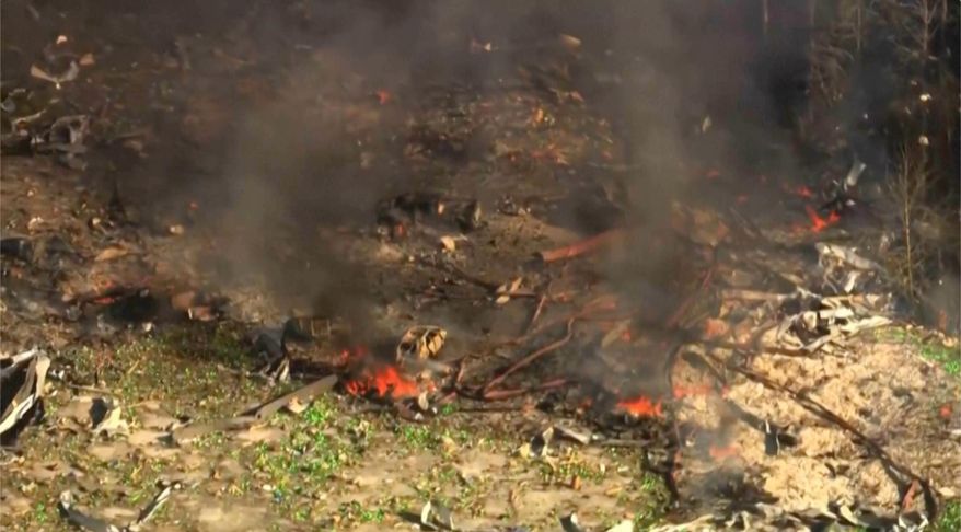 Smoke fills the air as debris covers the ground and vehicles after a powerful blast ripped through a military explosives manufacturing plant in Hickman County, Tenn., on Friday, Oct. 10, 2025. (WTVF-TV via AP)