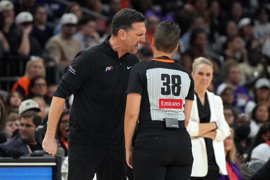 Phoenix Mercury head coach Nate Tibbetts, left, yells at official Lamont Simpson (38) after a foul during the second half of Game 4 of the WNBA basketball finals against the Las Vegas Aces, Friday, Oct. 10, 2025, in Phoenix. (AP Photo/Rick Scuteri)