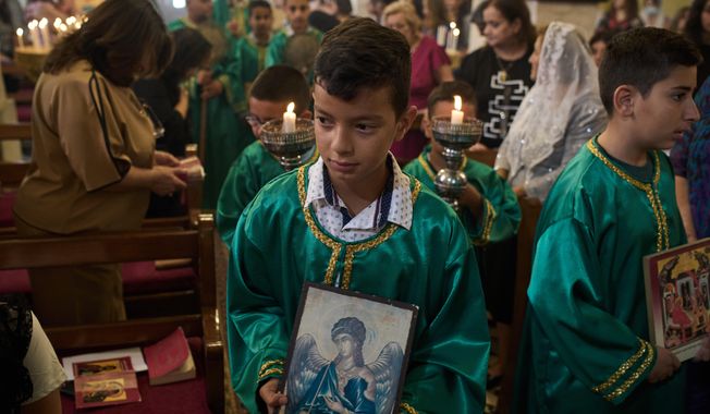 Palestinian children attend morning Mass at the Greek Orthodox Church of St. George in the West Bank village of Taybeh, Sept. 28, 2025. (AP Photo/Leo Correa)