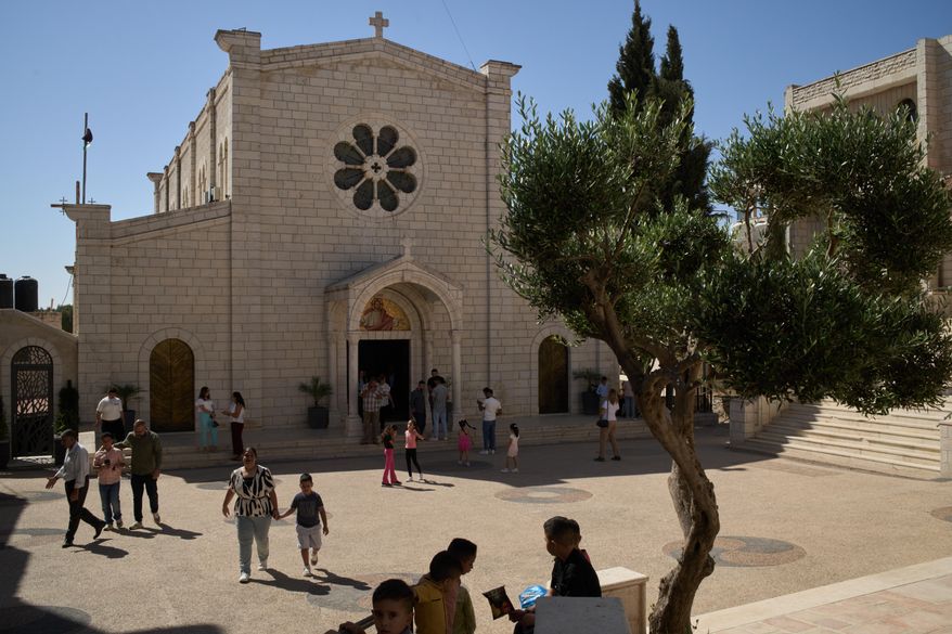 Palestinian parishioners stand outside Christ the Redeemer Church after attending a morning Mass in the West Bank village of Taybeh, Sept. 28, 2025. (AP Photo/Leo Correa)