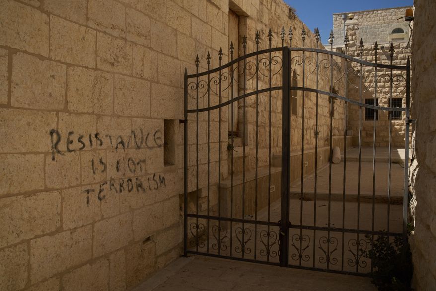 A message of resistance is written in English on a wall of an alley in the Old City of Taybeh, in the West Bank, Sept. 28, 2025. (AP Photo/Leo Correa)
