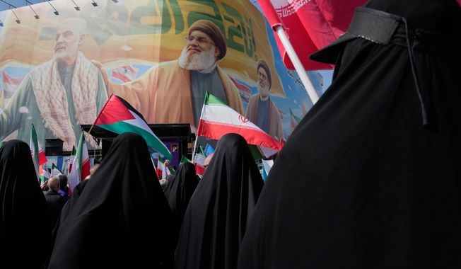 Iranian worshippers wave Palestinian and Iranian flags in front of a banner showing the late commander of the Iran's Revolutionary Guard expeditionary Quds Force, Gen. Qassem Soleimani, left, and two late Hezbollah leaders Hassan Nasrallah, center, and Hashem Safieddine, during an anti-Israeli rally after the Friday prayers at the Enqelab-e-Eslami (Islamic Revolution) square, in Tehran, Iran, Friday, Oct. 10, 2025. (AP Photo/Vahid Salemi)