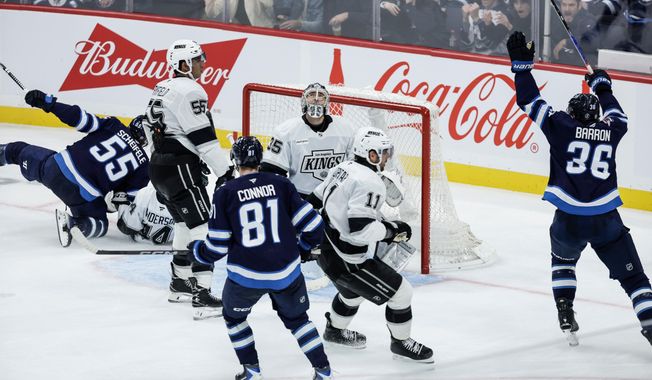 Winnipeg Jets' Kyle Connor (81) and Morgan Barron (36) look on as Mark Scheifele (55) shot gets past Los Angeles Kings goaltender Darcy Kuemper (35) during the second period of an NHL game in Winnipeg, Manitoba, Saturday, Oct. 11, 2025. (John Woods/The Canadian Press via AP)