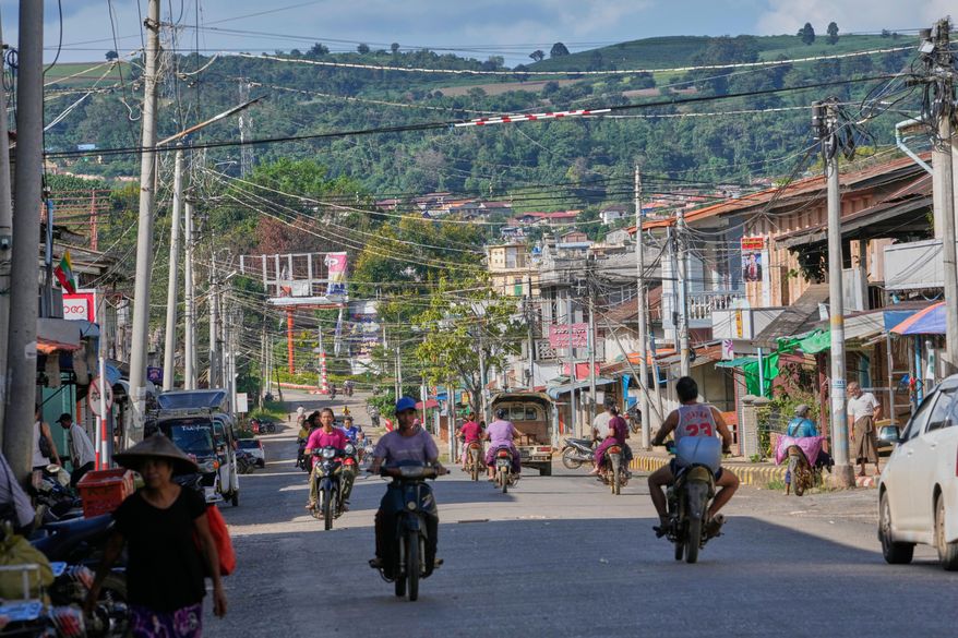 In this photo taken during a trip supervised by pro-military Myanmar media, locals ride motorbikes on a road in Kyaukme, northern Shan State, Myanmar, Friday, Oct. 10, 2025. (AP Photo/Aung Shine Oo)