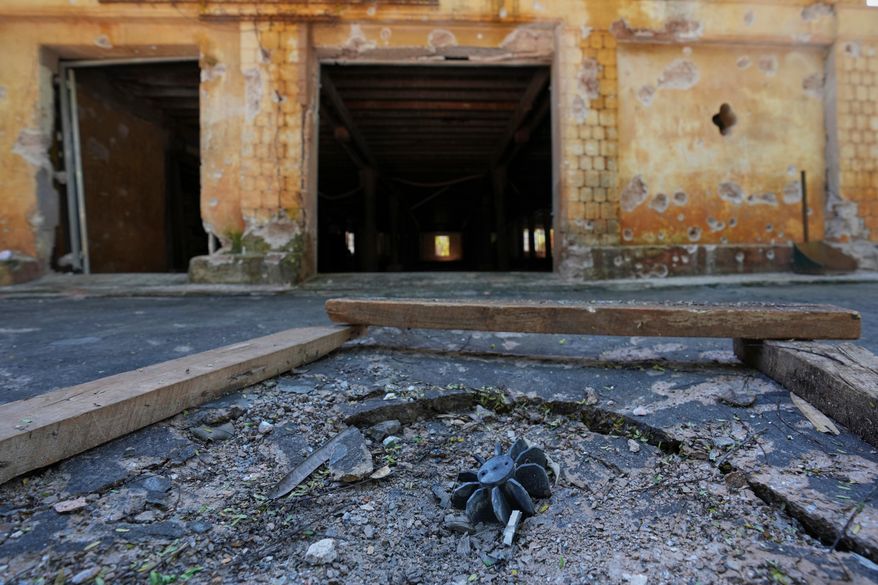 In this photo taken during a trip supervised by pro-military Myanmar media, an exploded ordnance lies in the ground in Kyaukme, northern Shan State, Myanmar, Friday, Oct. 10, 2025. (AP Photo/Aung Shine Oo)