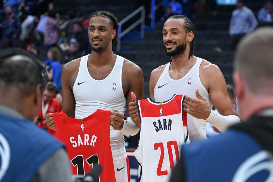 Washington Wizards center Alex Sarr (20) and his brother Toronto Raptors center Olivier Sarr (11) exchange jerseys after the Raptors’ 113-112 win in a preseason NBA game at Capital One Arena in Washington D.C., October 12, 2025. (Photo for the Washington Times)