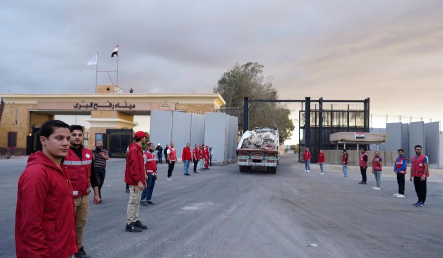 Egyptian Red Crescent members monitor a truck carrying humanitarian aids as it enters the Rafah crossing between Egypt and the Gaza Strip, following an agreement between Israel and Hamas on a ceasefire, Sunday, Oct. 12, 2025. (AP Photo/Mohamed Arafat) ** FILE **