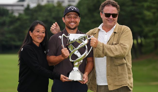 Xander Schauffele, of the U.S., poses for a photo with his parents, Chen Ping-Yi, left, and Stefan Schauffele, as he won the Baycurrent Classic golf tournament at the Yokohama Country Club in Yokohama, near Tokyo, Sunday, Oct. 12, 2025. (AP Photo/Hiro Komae)