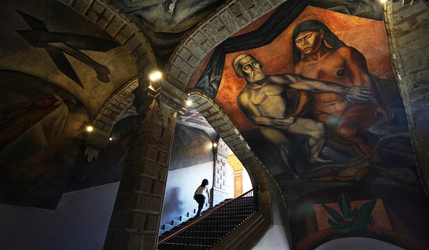 A 1926 fresco of Hernan Cortes and La Malinche by Jose Clemente Orozco decorates the Antiguo Colegio de San Ildefonso in Mexico City, Wednesday, April 26, 2023. (AP Photo/Marco Ugarte)