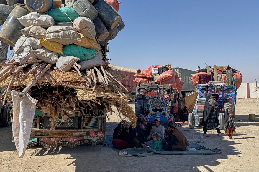 Afghan refugees sit next to their belongings loaded onto vehicles as they wait for opening of the border crossing point, which closed following Afghan and Pakistani security forces exchanged cross border firing, at a camp in Chaman, Pakistan, Sunday, Oct. 12, 2025. (AP Photo)