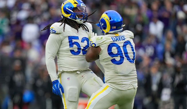 Los Angeles Rams defensive end Larrell Murchison (52) reacts with defensive end Tyler Davis (90) after a play against the Baltimore Ravens during the second half of an NFL football game Sunday, Oct. 12, 2025, in Baltimore. (AP Photo/Stephanie Scarbrough)