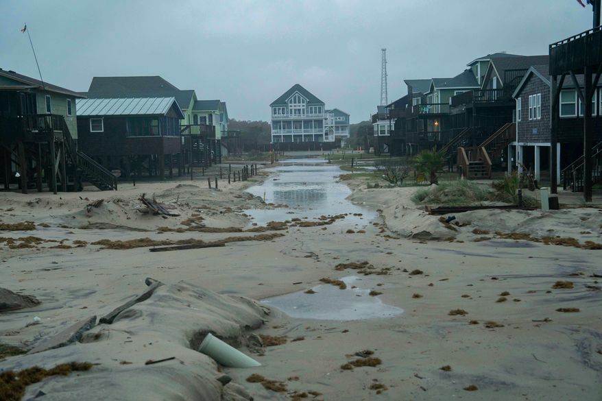A flooded road is seen in the midst of a storm, Sunday, Oct. 12, 2025, in Buxton, N.C. (AP Photo/Allison Joyce)