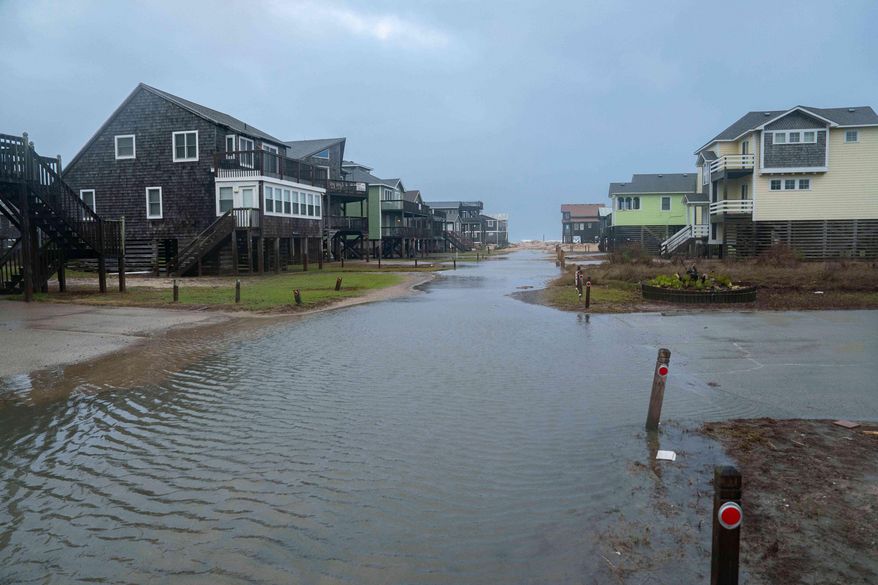 A flooded road is seen in the midst of a storm, Sunday, Oct. 12, 2025, in Buxton, N.C. (AP Photo/Allison Joyce)
