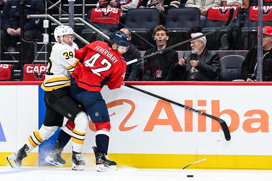 Washington Capitals defenseman Martin Fehervary (42) bodies Boston Bruins center Morgan Geekie (39) into the boards at Capital One Arena, Washington, D.C., October 8, 2025. (Photo by Brian Murphy for the Washington Times)