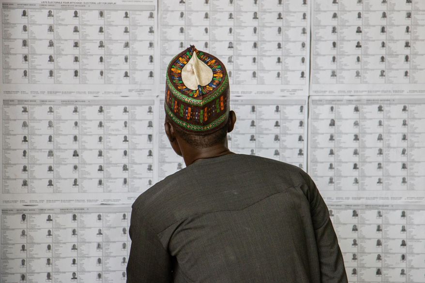 A voter checks his name on the voters' list before casting his ballot at a polling station in Garoua, Cameroon, Sunday, Oct. 12, 2025 (AP Photo/Welba Yamo Pascal)