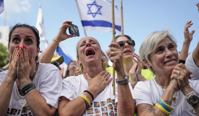 People react as they gather to watch a live broadcast of Israeli hostages released from Gaza at a plaza known as hostages square in Tel Aviv, Israel, Monday, Oct. 13, 2025. (AP Photo/Oded Balilty)